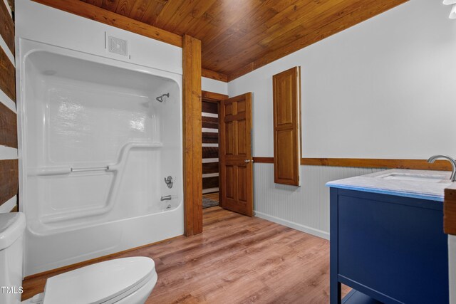 full bathroom featuring toilet, hardwood / wood-style floors, vanity, and washtub / shower combination