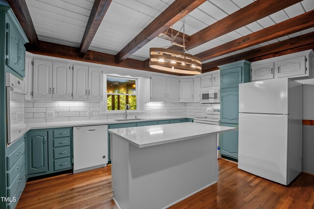 kitchen with white appliances, white cabinetry, sink, and a kitchen island