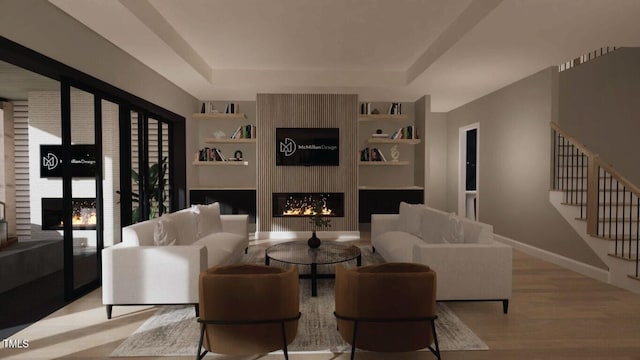 living room with built in shelves, light hardwood / wood-style flooring, and a large fireplace