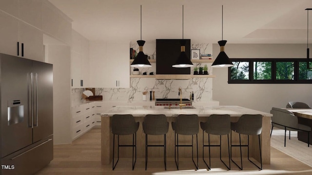 kitchen with stainless steel refrigerator with ice dispenser, sink, light stone counters, decorative backsplash, and white cabinets