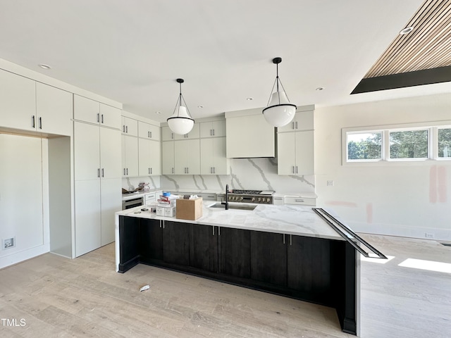 280 Forest Bridge Rd, Youngsville, NC 27596 - kitchen featuring white cabinets, light wood-style floors, pendant lighting, a large island, and light stone countertops