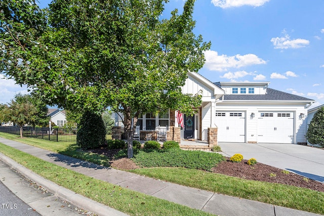 view of front of house with a front yard, a garage, and covered porch