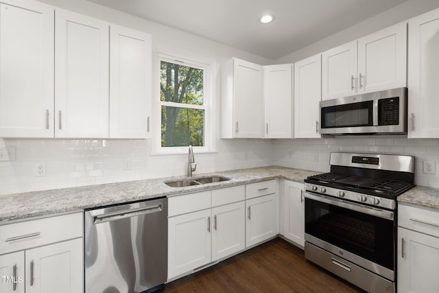 kitchen featuring dark wood-type flooring, white cabinets, sink, light stone countertops, and stainless steel appliances