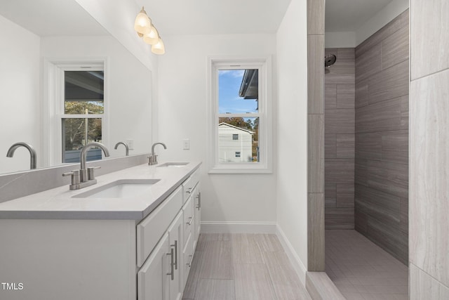 bathroom featuring tiled shower and vanity