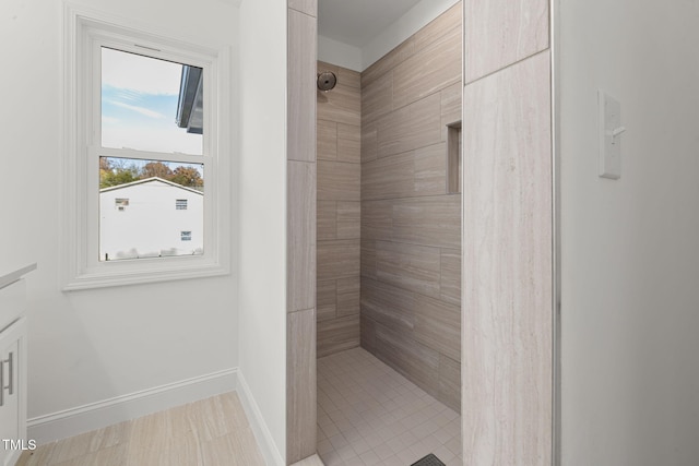 bathroom featuring a tile shower, vanity, and hardwood / wood-style floors