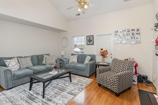 living room with light hardwood / wood-style floors, high vaulted ceiling, and ceiling fan