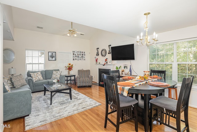 dining space featuring ceiling fan with notable chandelier and light hardwood / wood-style flooring