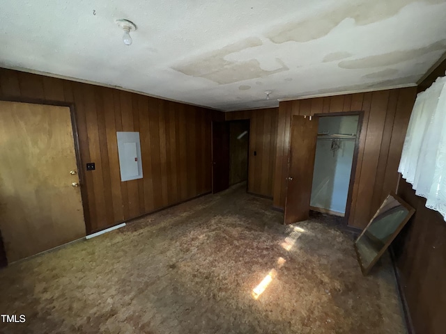 interior space featuring electric panel and wooden walls