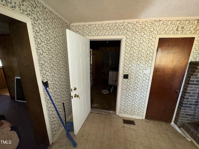 interior space featuring a textured ceiling and ornamental molding