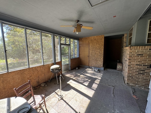 unfurnished sunroom with ceiling fan and plenty of natural light