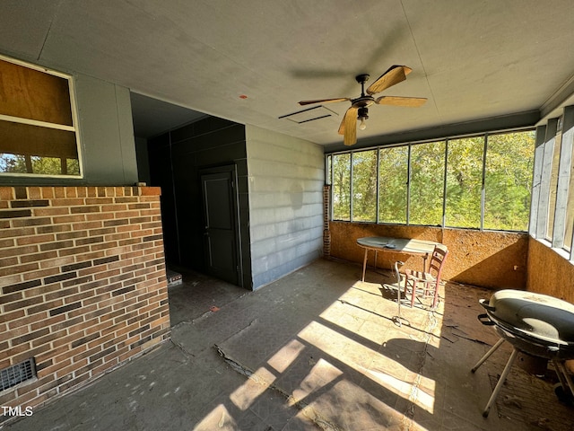 unfurnished sunroom featuring ceiling fan