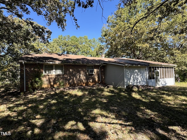 view of front of home featuring a front lawn and a sunroom