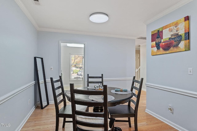 dining space featuring light hardwood / wood-style flooring and ornamental molding