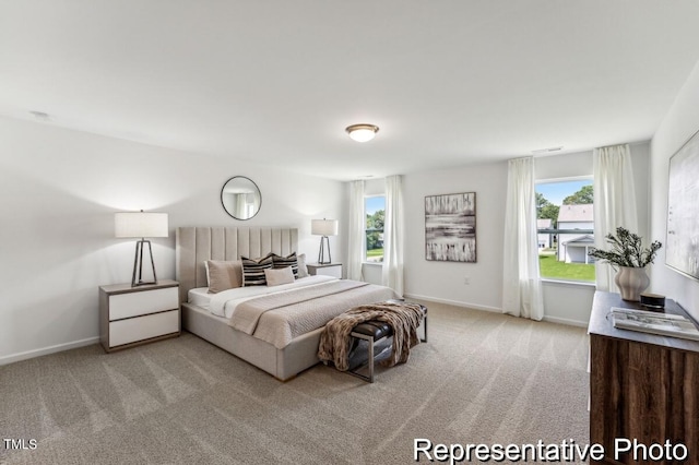 bedroom featuring multiple windows and light carpet