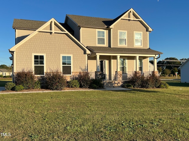 craftsman-style house with a front lawn and covered porch