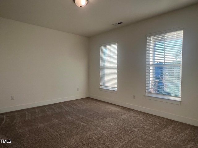 unfurnished room with dark carpet