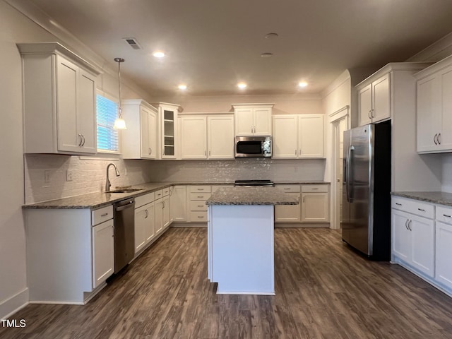 kitchen with light stone counters, dark wood-type flooring, white cabinetry, appliances with stainless steel finishes, and a center island