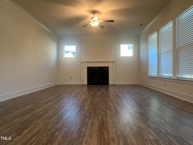 unfurnished living room with ceiling fan, plenty of natural light, dark hardwood / wood-style flooring, and crown molding