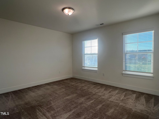 unfurnished room with dark carpet