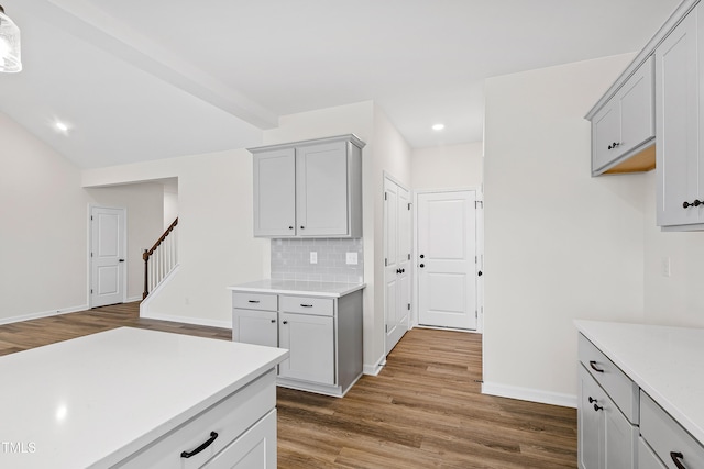 kitchen featuring gray cabinets, decorative backsplash, and wood-type flooring