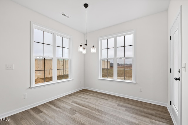 unfurnished dining area featuring light wood-type flooring