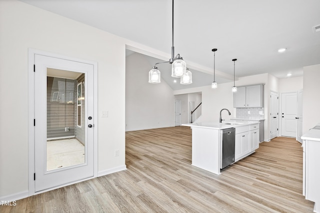 kitchen featuring white cabinetry, sink, dishwasher, pendant lighting, and light wood-type flooring