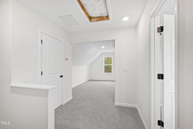 hallway featuring light carpet and lofted ceiling