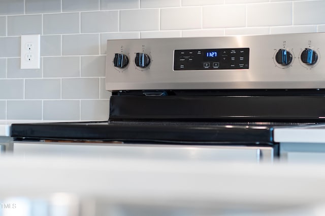 room details featuring electric range and tasteful backsplash