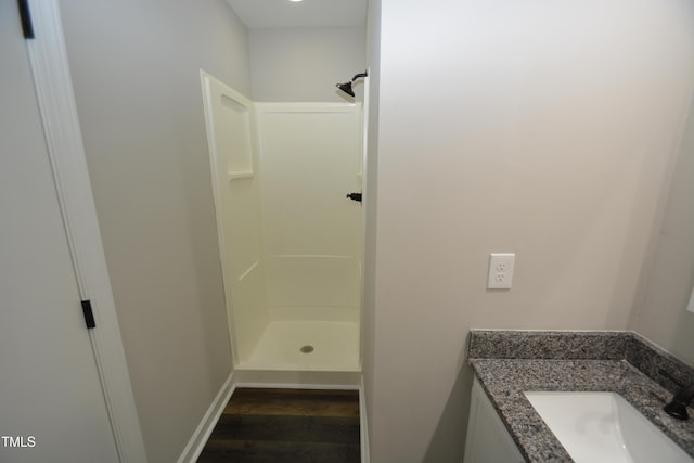 bathroom featuring vanity, a shower, and hardwood / wood-style floors