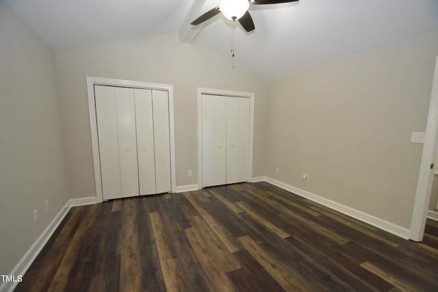 unfurnished bedroom with two closets, vaulted ceiling with beams, ceiling fan, and dark hardwood / wood-style flooring