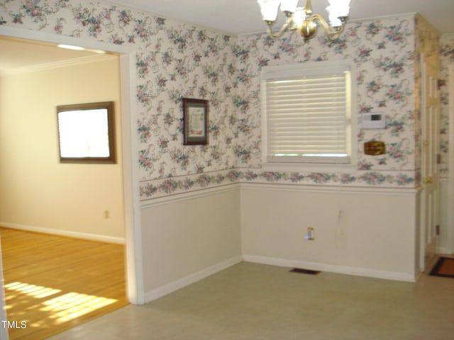 empty room with a notable chandelier, crown molding, and hardwood / wood-style floors