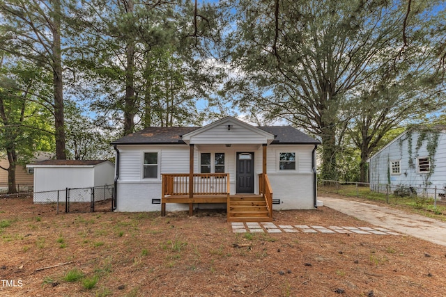 view of front of property with brick siding, fence, and a shingled roof