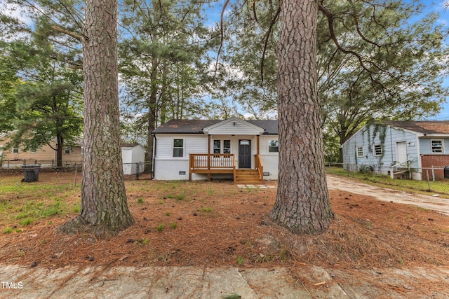 bungalow-style house featuring roof with shingles, crawl space, fence, and a deck