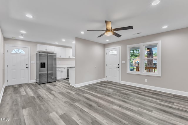 unfurnished living room with light wood-type flooring and ceiling fan