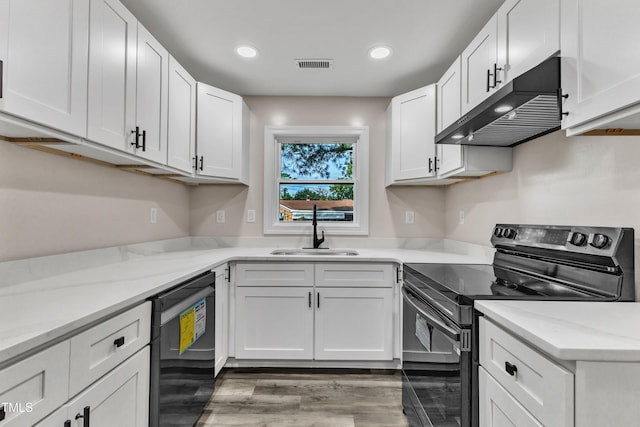 kitchen featuring black / electric stove, under cabinet range hood, dishwasher, visible vents, and a sink