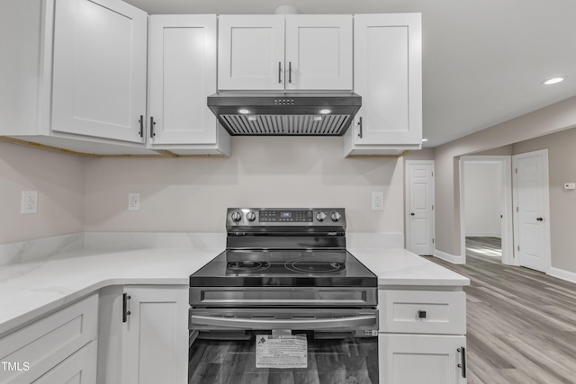 kitchen featuring white cabinets, extractor fan, stainless steel range with electric stovetop, and light wood-style flooring
