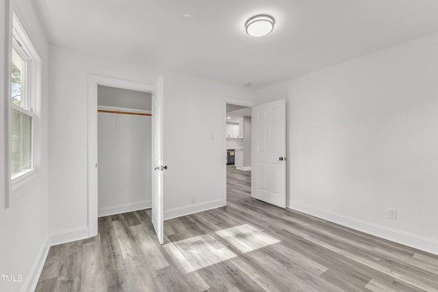 unfurnished bedroom with light wood-type flooring and a closet