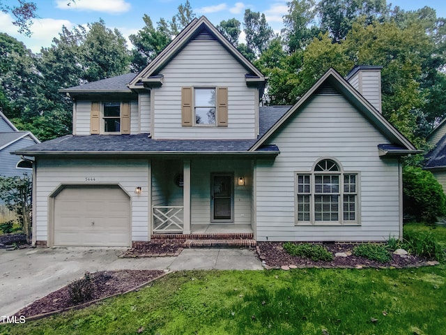 view of front of property with a front lawn, a garage, and covered porch