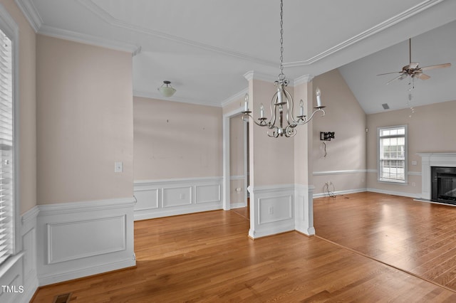 unfurnished dining area with ornamental molding, wood-type flooring, and vaulted ceiling