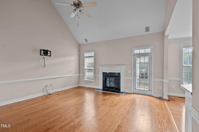 unfurnished living room with light hardwood / wood-style floors, ceiling fan, and high vaulted ceiling