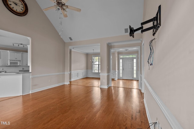 3806 Wyattwood Dr N, Wilson, NC 27896 - unfurnished living room with light wood-style flooring, wainscoting, visible vents, ceiling fan, and high vaulted ceiling