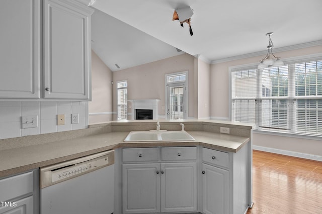 kitchen featuring backsplash, white dishwasher, light wood-type flooring, lofted ceiling, and sink