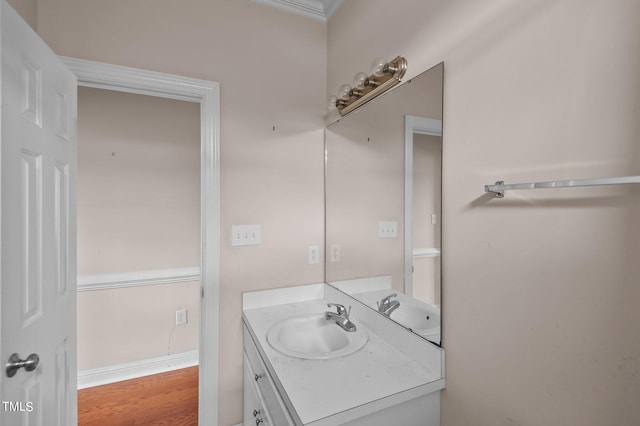 bathroom featuring ornamental molding, wood-type flooring, and vanity