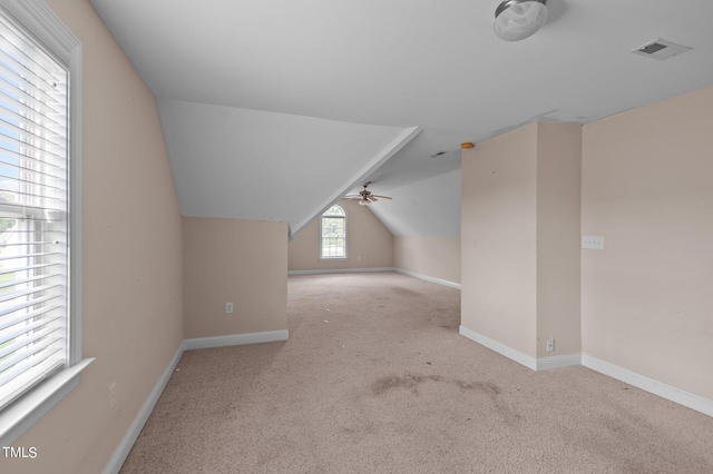 additional living space featuring light carpet, lofted ceiling, and ceiling fan