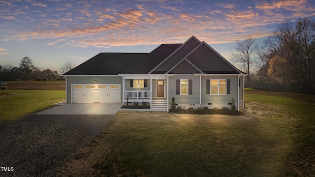 view of front facade with a porch, a garage, and a lawn