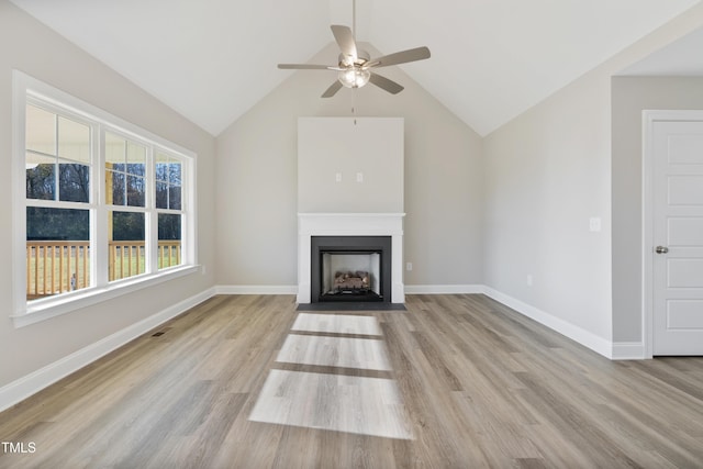 unfurnished living room with ceiling fan, light hardwood / wood-style flooring, a healthy amount of sunlight, and lofted ceiling