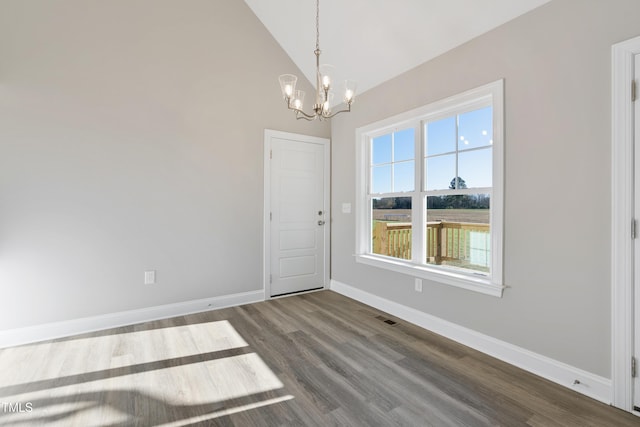 unfurnished dining area with vaulted ceiling, wood-type flooring, and an inviting chandelier