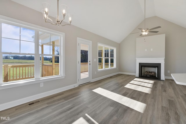 unfurnished living room featuring ceiling fan with notable chandelier, wood-type flooring, and lofted ceiling