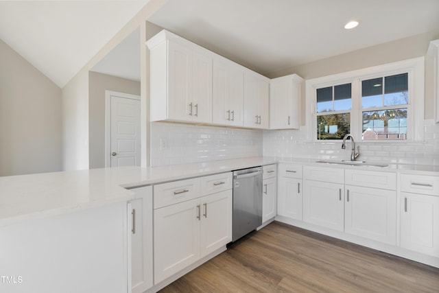 kitchen featuring white cabinetry, dishwasher, sink, tasteful backsplash, and wood-type flooring