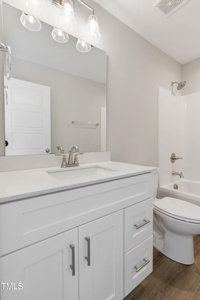 full bathroom featuring wood-type flooring, vanity, toilet, and shower / washtub combination